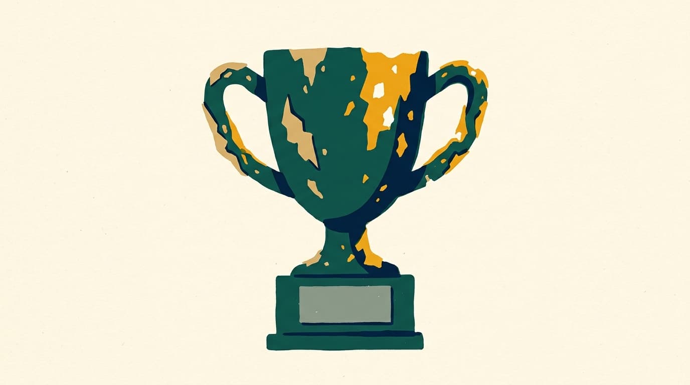A crumbling papier-mâché trophy with flaking gold paint and a blank, dusty nameplate